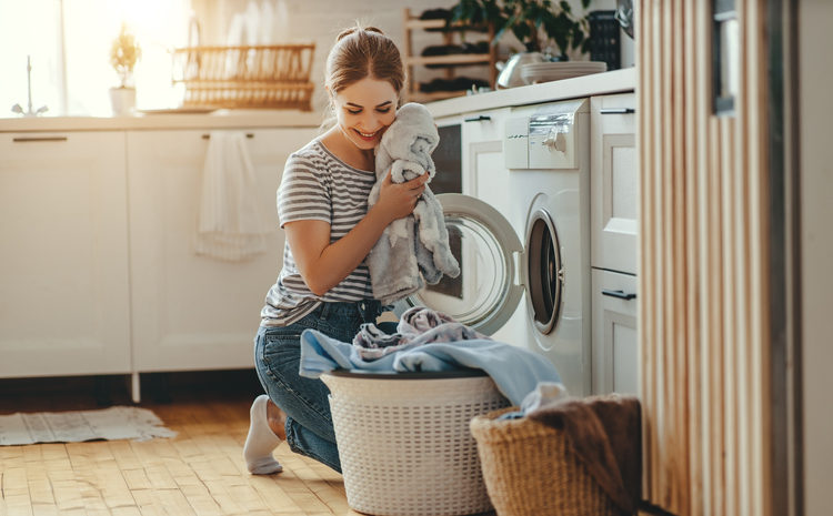 Žena vadi veš iz kombinovana mašina za pranje i sušenje
