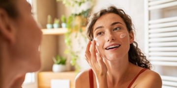 Da li previše kozmetike šteti koži; žena koja nanosi kremu na lice