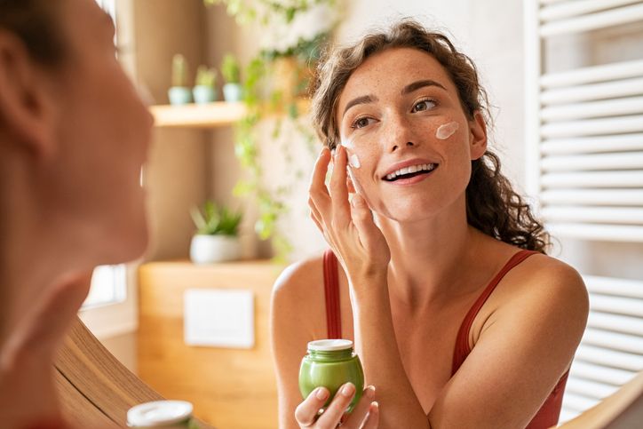 Da li previše kozmetike šteti koži; žena koja nanosi kremu na lice