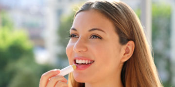 Suve i ispucale usne: Možda koristite pogrešan balzam za usne; devojka nanosi balzam na usne