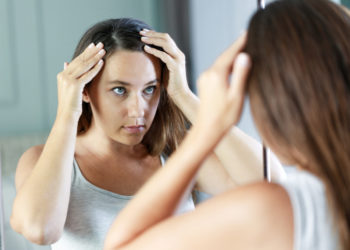 Kako se rešiti peruti: 6 jednostavnih koraka; devojka proverava kosu