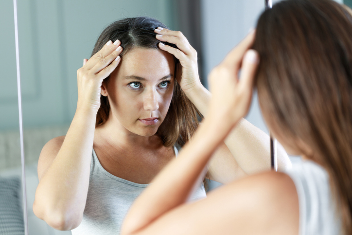 Kako se rešiti peruti: 6 jednostavnih koraka; devojka proverava kosu