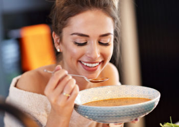 Kako ubrzati metabolizam: Ključno je vreme kad večerate; žena jede supu za večeru