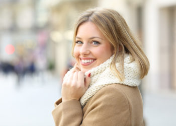Kako negovati kožu tokom grejne sezone; devojka u toploj odeći koja ima zdravu kožu