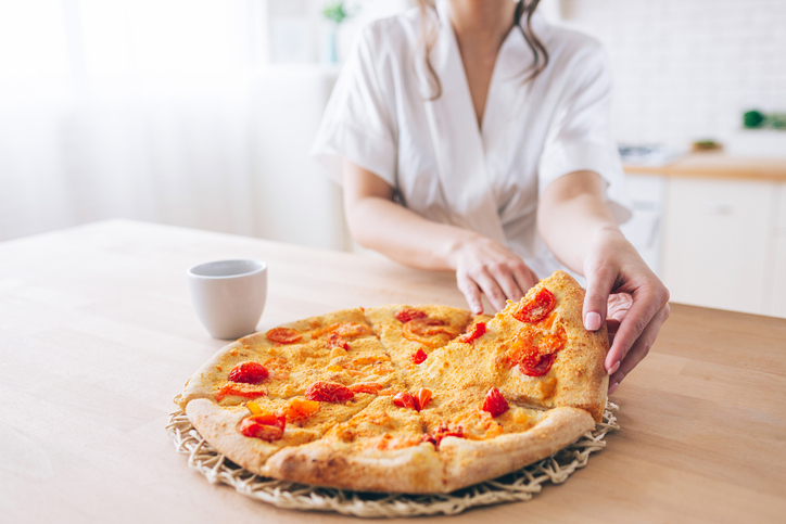 Kako smanjiti nivo grelina – hormona zbog kojeg se gojite; žena se sprema da pojede celu picu