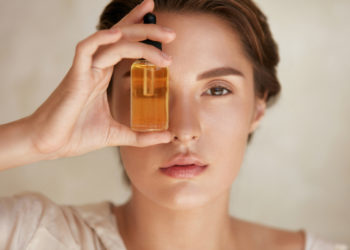 Kako se koristi ulje za lice i zašto nam je potrebno; devojka drži flašicu sa uljem za lice