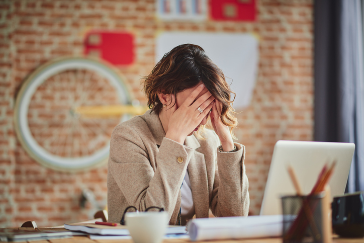 Stres na poslu: Kako sprečiti da vam se stres sa posla ne preliva na ceo život; žena koja je pod stresom na poslu