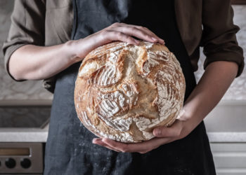 Koliko hleba možete jesti dnevno a da se ne ugojite; ruke koje drže rustični hleb