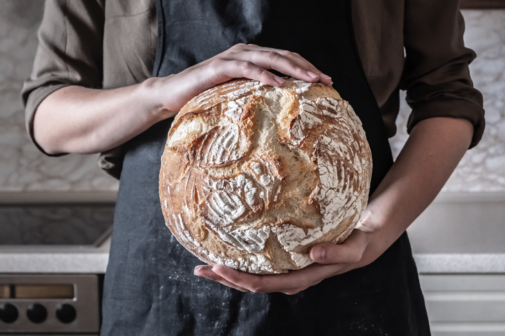Koliko hleba možete jesti dnevno a da se ne ugojite; ruke koje drže rustični hleb