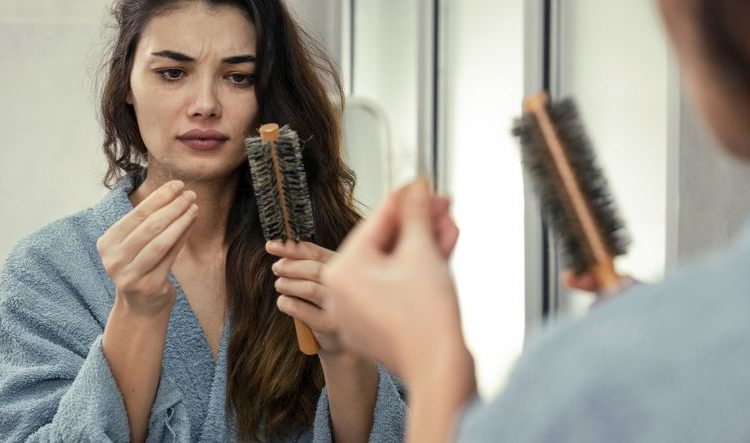 Mršavljenje i gubitak kose: Kako dijete utiču na kosu; žena zabrinuto gleda gomilu kose koja je ostala na četki nakon češljanja