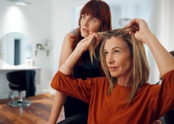 Zašto opada kosa nakon pedesete i kako se izboriti sa tim; žena u pedesetim pokazuje svojoj frizerki koliko joj je kose opalo