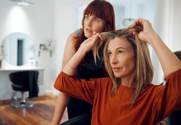 Zašto opada kosa nakon pedesete i kako se izboriti sa tim; žena u pedesetim pokazuje svojoj frizerki koliko joj je kose opalo