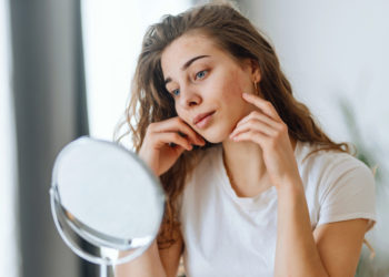 Kako da uklonite mitisere na pravi način; devojka koja gleda svoje mitisere u ogledalu