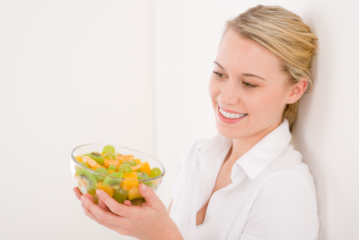 PMS dijeta: Zdrava hrana ublažavanje menstrualne tegobe; devojka drži činiju sa svežim voćem koje ublažava PMS