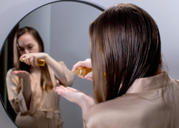 Ulje peperminta za bujnu i zdravu kosu; devojka stavlja ulje peperminta na kosu