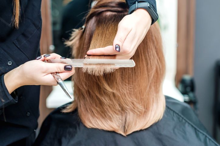 Da li šišanje ubrzava rast kose; frizerka šiša ženi kosu u frizerskom salonu