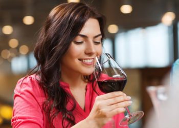 Crveno vino: Da li podiže ili snižava krvni pritisak; žena u roze košulji pije crveno vino
