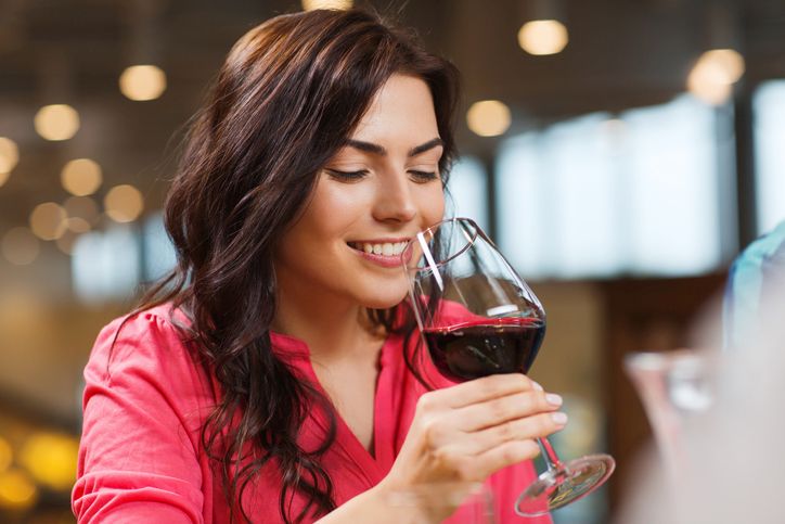 Crveno vino: Da li podiže ili snižava krvni pritisak; žena u roze košulji pije crveno vino