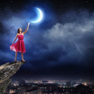 Mesec u ženskom horoskopu otkriva karakter; žena u crvenoj haljini dodiruje Mesec rukom