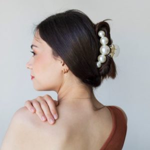 Jednostavne frizure sa šnalom za kosu; crnokosa devojka koja je sakupila kosu šnalom sa krupnim biserima