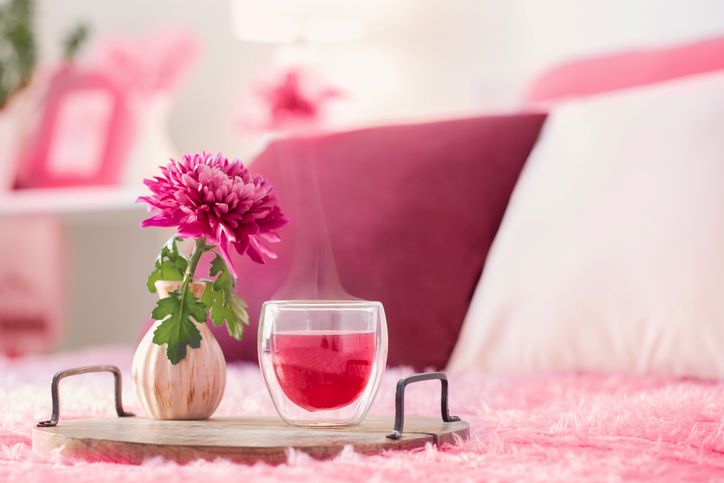 Kako da brzo privučete ljubav pomoću Feng šuija; Poslužavnik sa pink cvetom i šoljom čaja na krevetu u pink nijansama koje privlače ljubav
