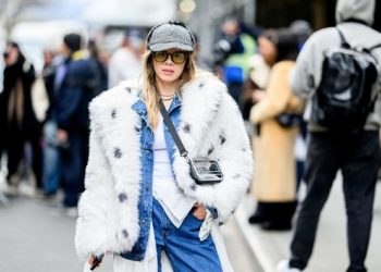 New York Fashion Week Street Style: 5 trendova koji vladaju; savršeno stilizovana devojka, u bundi i farmericama, sa kačketom naočarima, pozira na gradskoj ulici