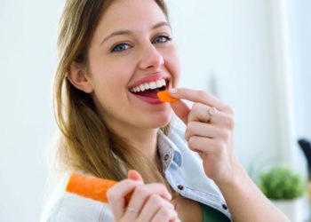 Šargarepa nije dobra samo za vid – pomoći će vam i da smršate; lepa, nasmejana žena jede šargarepu