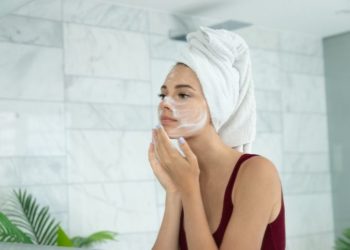 Kako odabrati najbolji čistač za lice prema tipu kože; lepa, mlada devojka nanosi proizvod za čišćenje na svoje lice