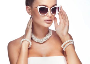 Kako nositi bisernu ogrlicu ako želite da izgledate moderno; atraktivna devojka s modernim sunčanim naočarima, bisernom ogrlicom i bisernim narukvicama