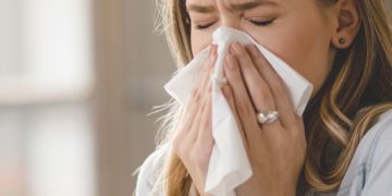 Kako razlikovati prehladu od alergije; devojka duva nos u maramicu