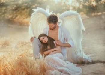 horoskopski znaci koje štite anđeli čuvari: anđeo čuvar s belim krilima drži u krilu dugokosu ženu u beloj haljini