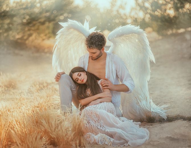horoskopski znaci koje štite anđeli čuvari: anđeo čuvar s belim krilima drži u krilu dugokosu ženu u beloj haljini