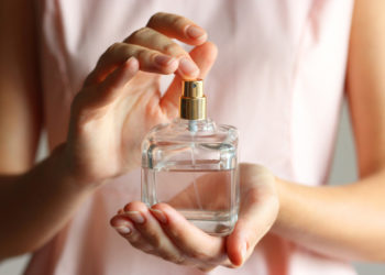 Neodoljivi parfemi iz Zare koji mirišu skupo; ženske ruke u krupnom planu koje drže bočicu parfema