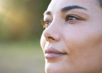Suva ili dehidrirana koža: Ženski profil slikan u krupnom planu s blurovanom zelenom pozadinom