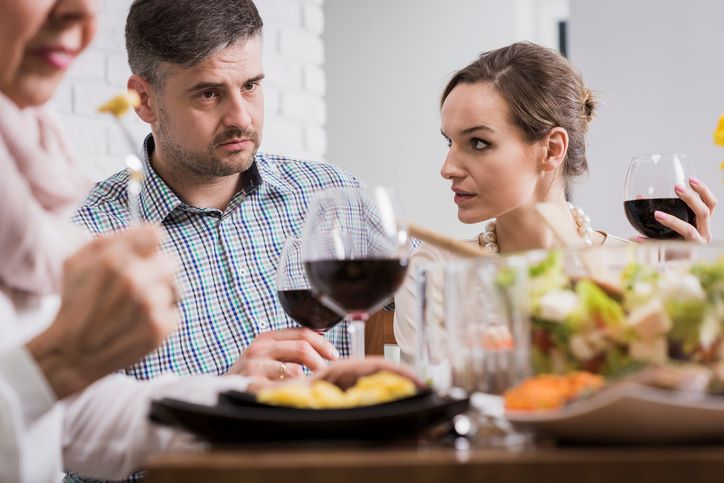 10 suptilnih znakova da vas njegovi roditelji ne vole; zabrinuti muškarac i žena sede za stolom, na ručku kod njegovih roditelja