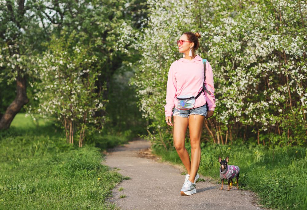 Najbolje patike s platformom; devojka u teksas šortsu, roze dukserici i patikama sa platformom šeta psa po parku